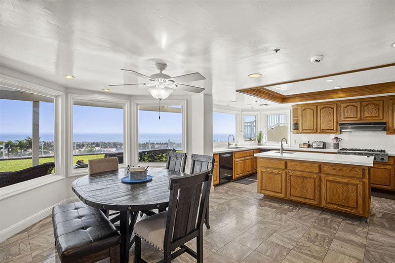 Spacious kitchen and dining area with wooden cabinets and ocean views.