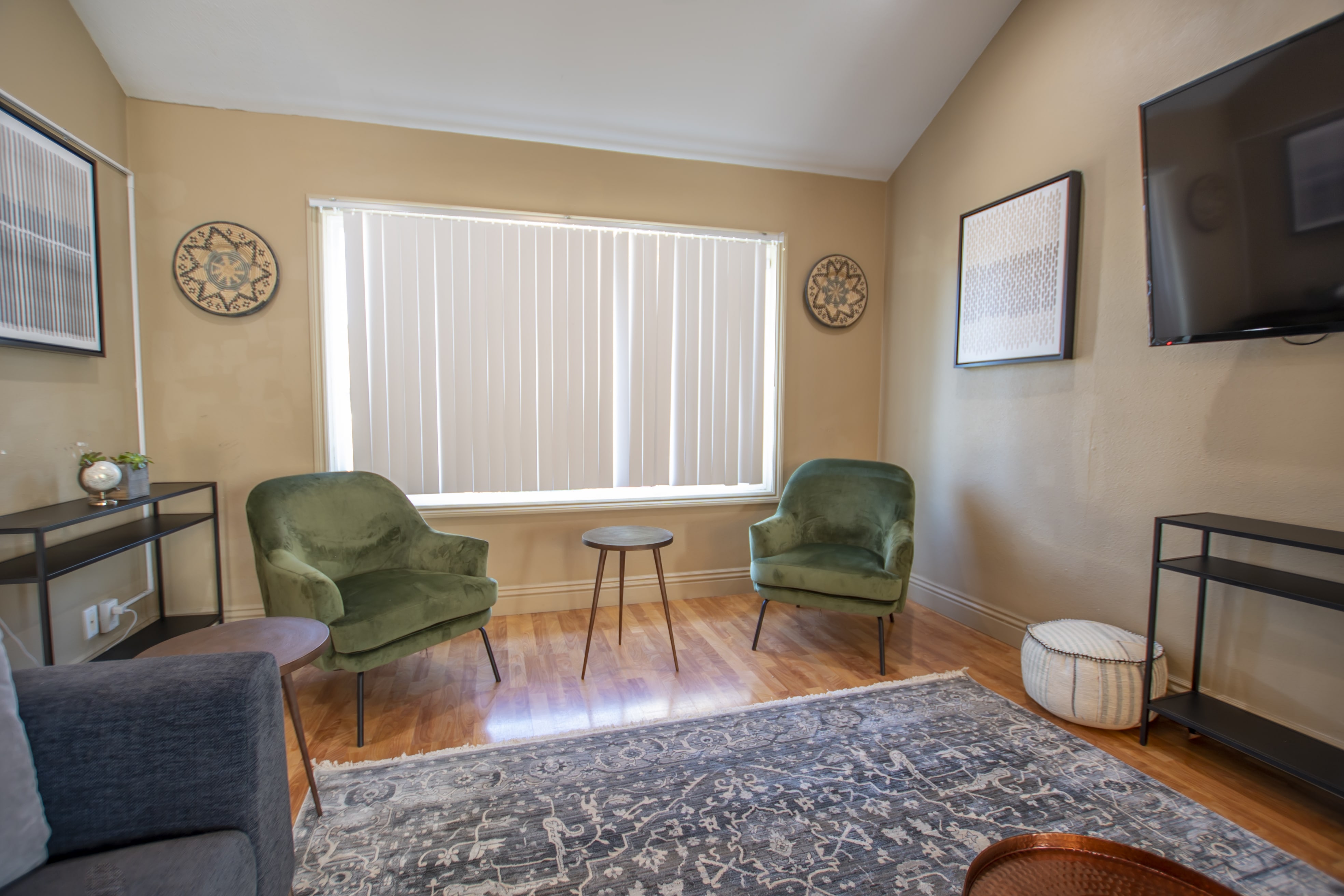Two green armchairs and a wall-mounted TV