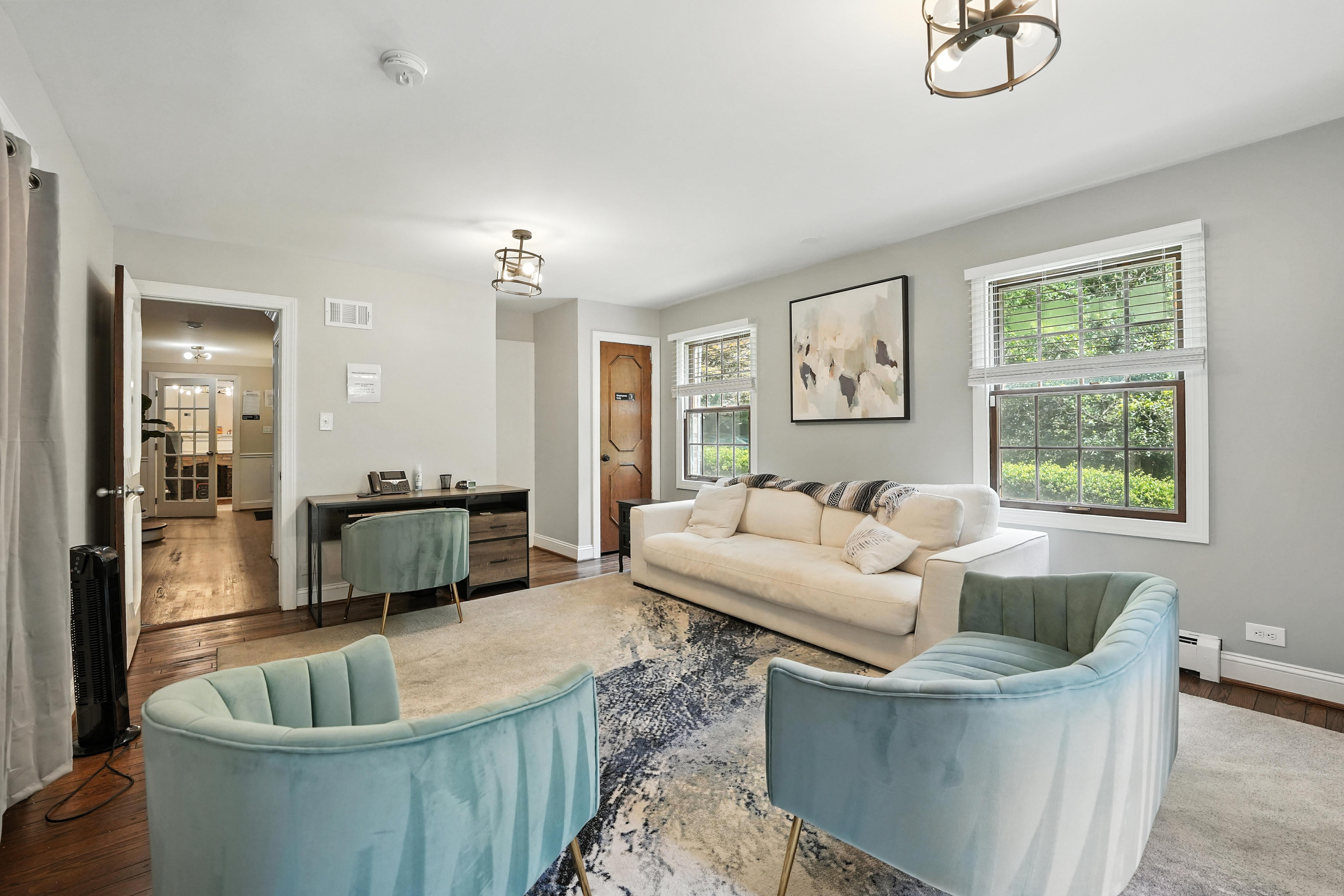 Counseling room with sofa, chairs, and desk by window
