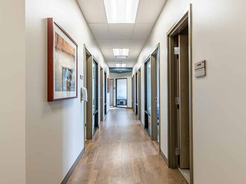 Clean residential hallway with treatment offices and patient rooms inside recovery center