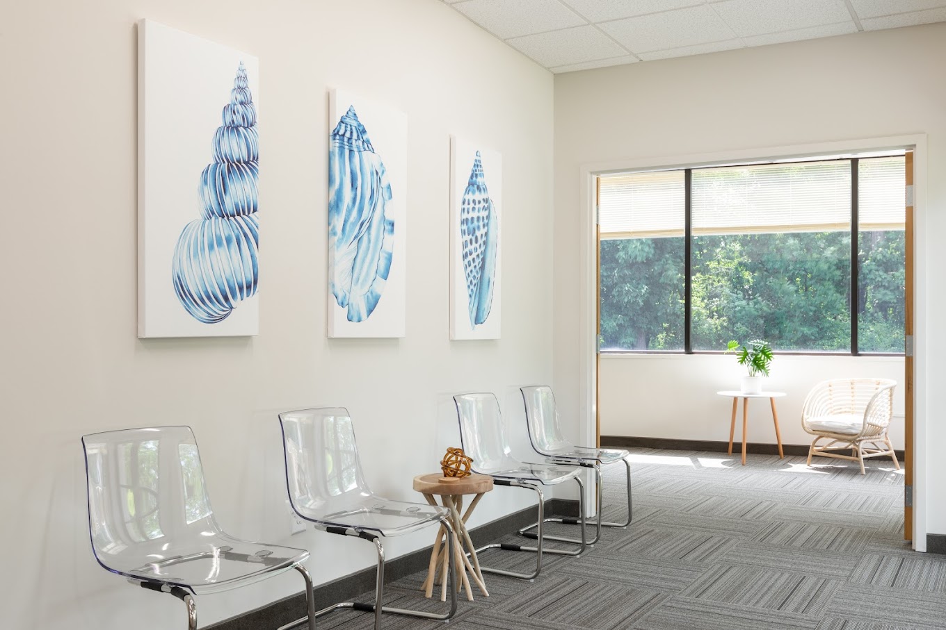 Waiting area with chairs,  and large windows.