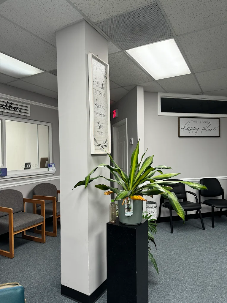 Lobby with chairs, wall art, and potted plant near check-in