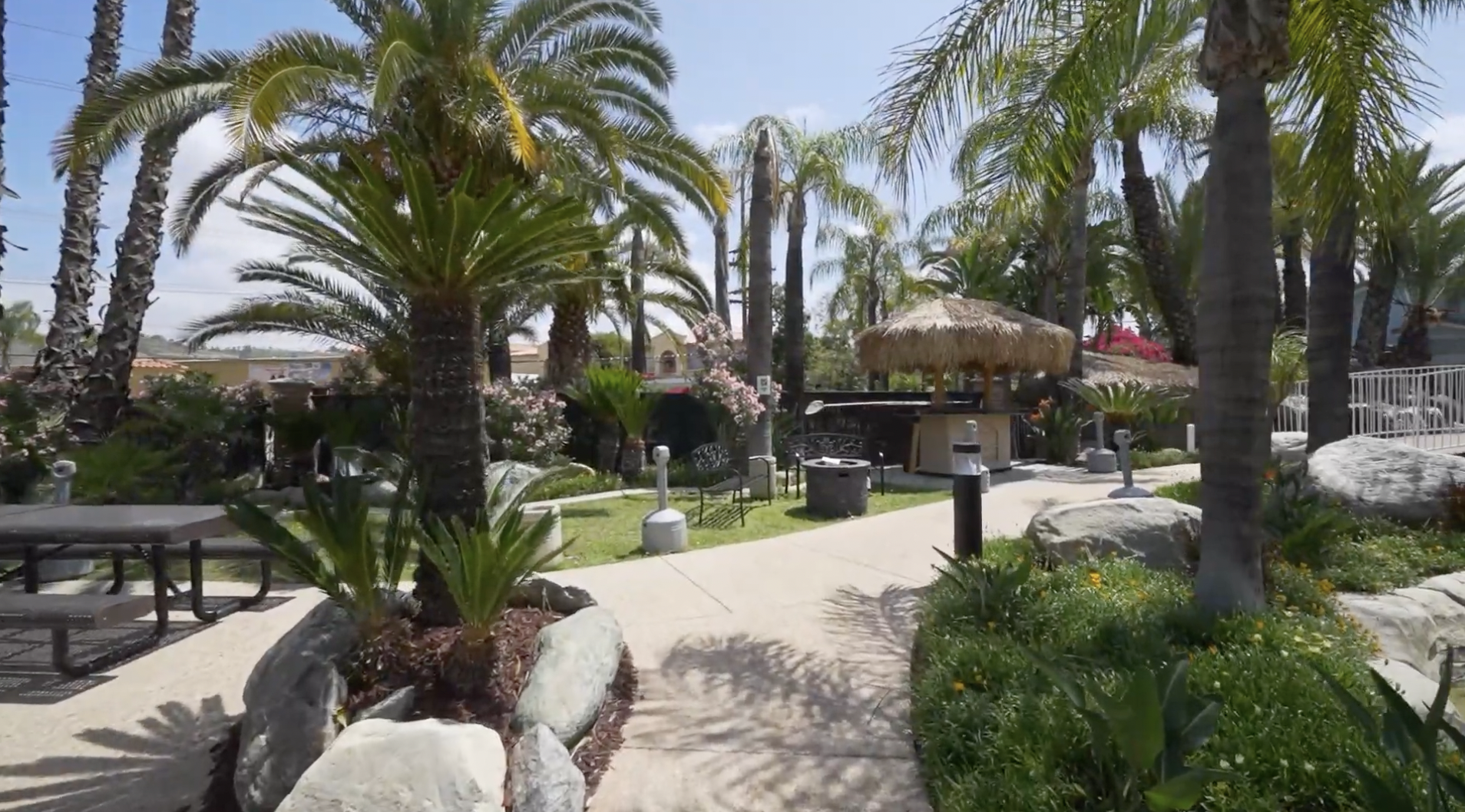 Pathway through tropical gardens with shaded seating areas
