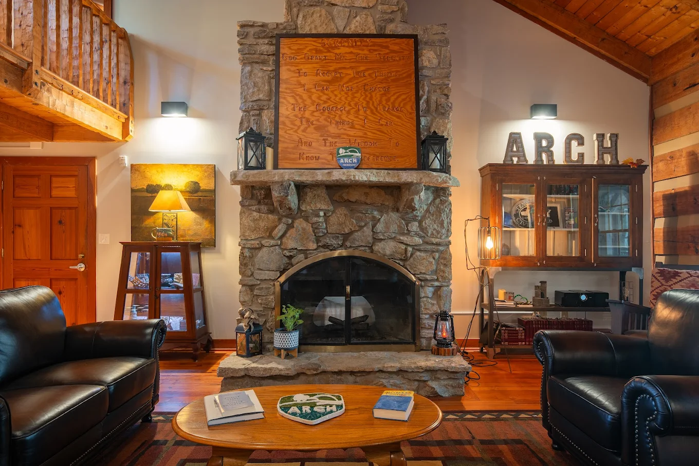 Cozy lodge-style living room with stone fireplace and leather seating.