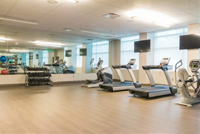 Exercise room with treadmills, weights, and large mirrors