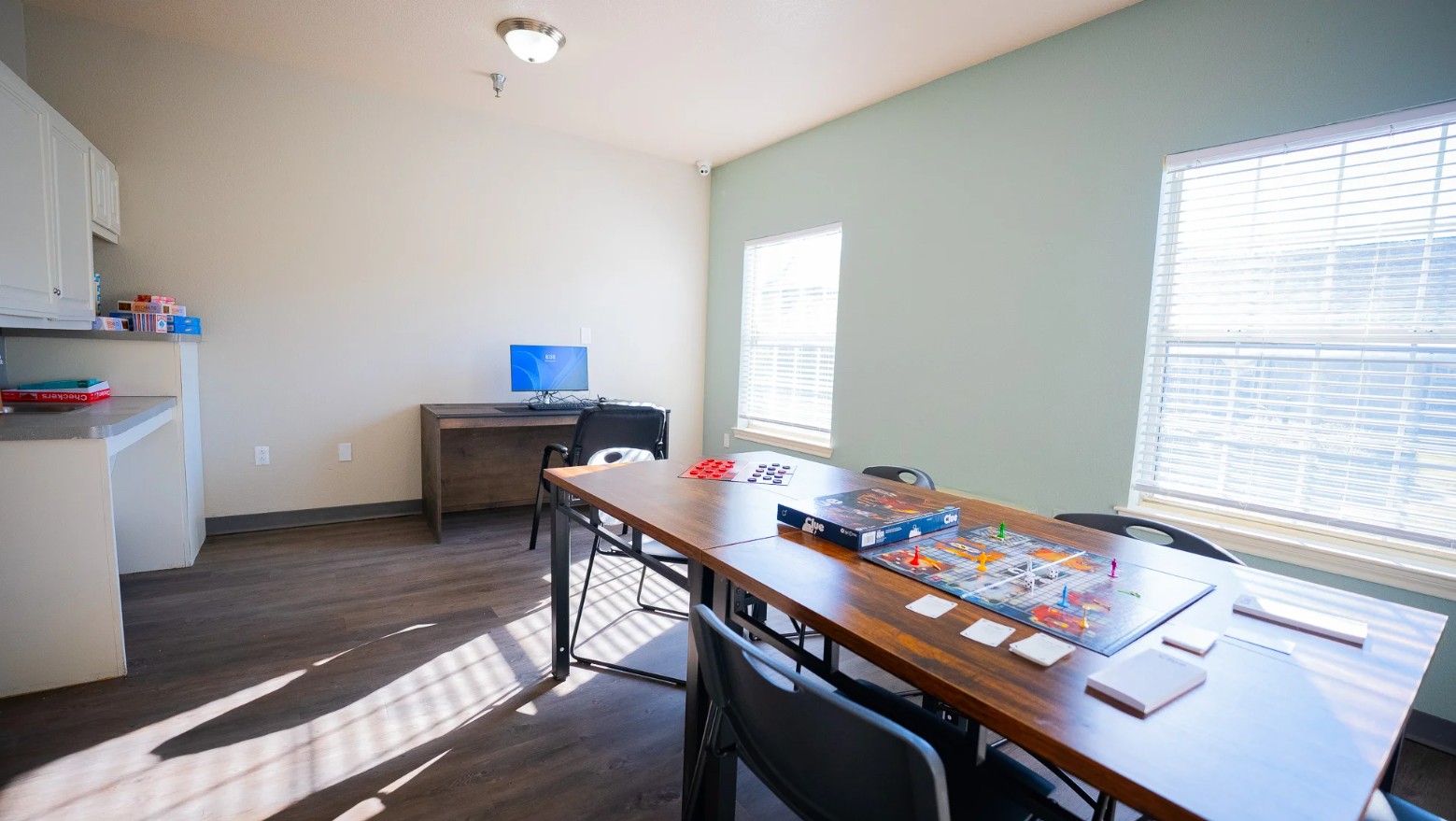 Recreation room with board games, table seating, and computer workstation for leisure activities