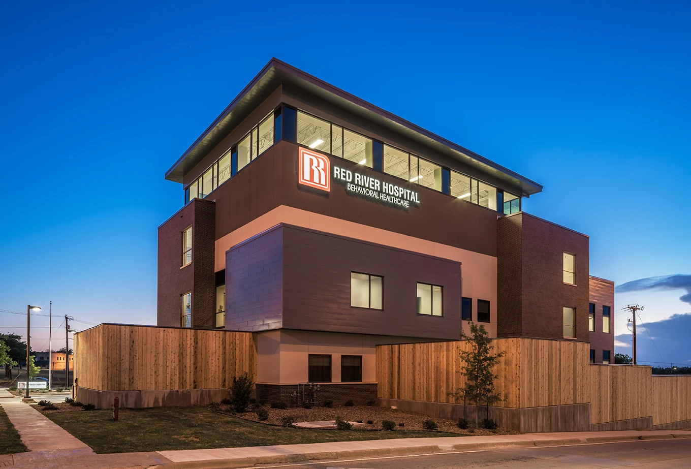 Exterior of Red River Hospital illuminated at dusk.