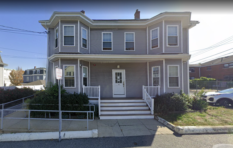 Gray two-story house with white porch and accessibility ramp