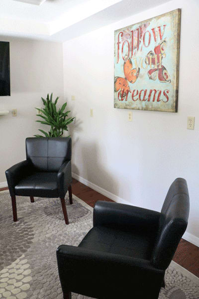 Two black chairs and art with “follow your dreams”