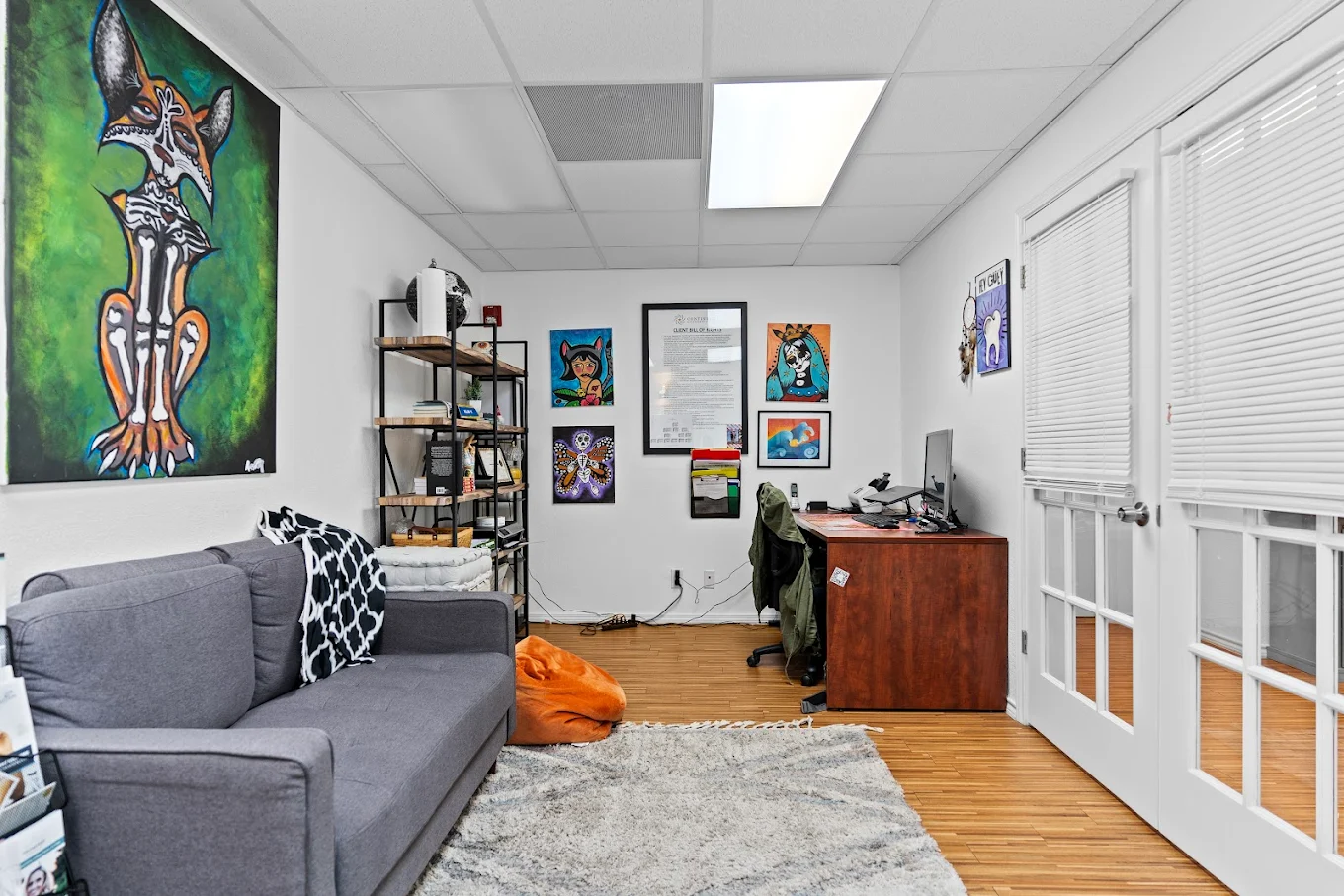 Counseling room with sofa, desk, and colorful wall artwork