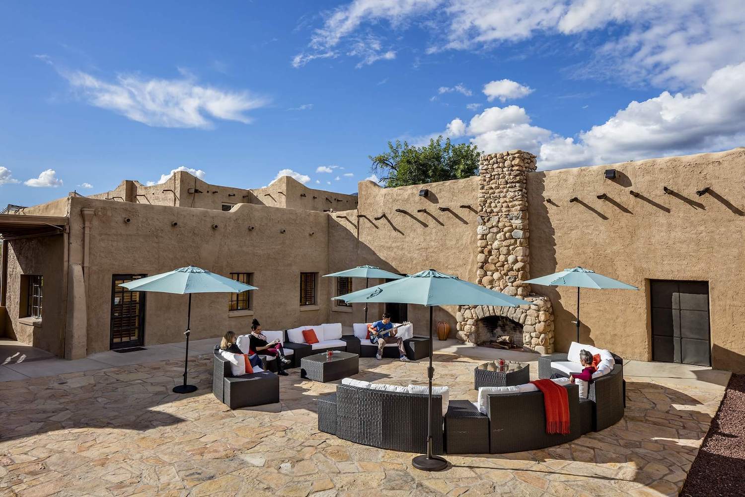 Courtyard with circular seating and umbrellas for group therapy at Sabino Recovery