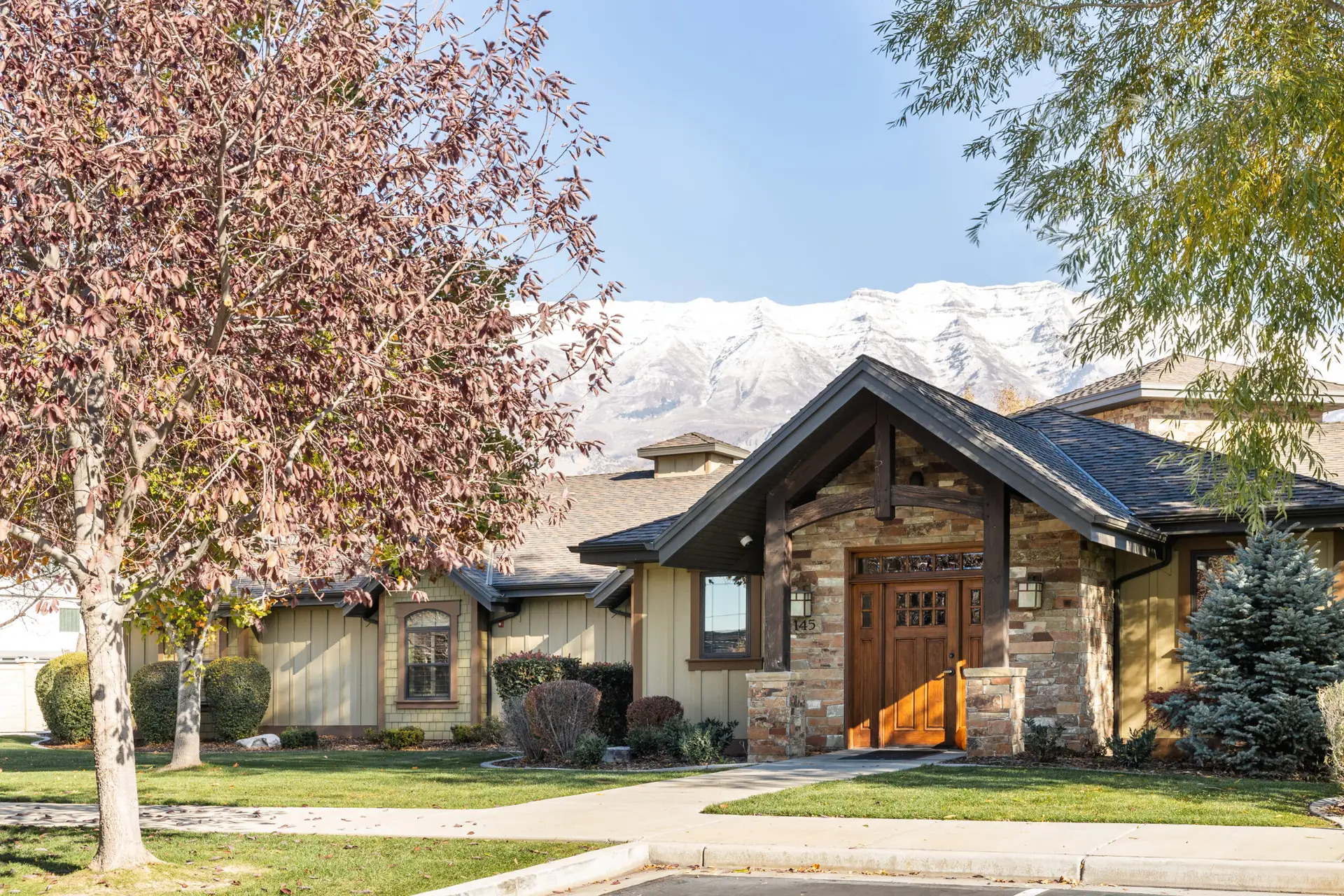 Wooden entrance framed by trees and mountain backdrop