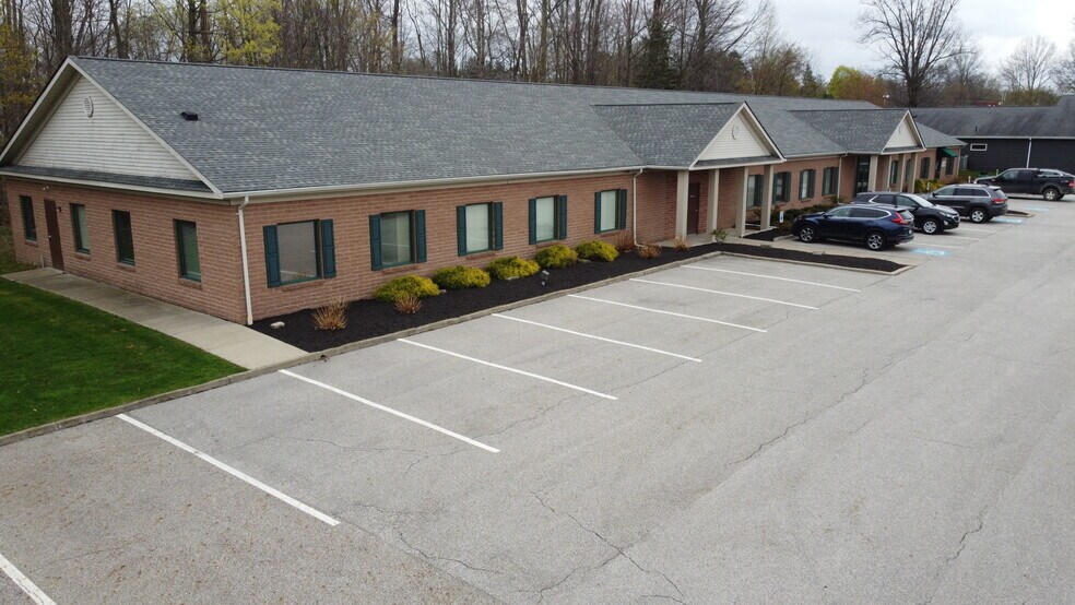 Long brick building with front lot and several parked cars