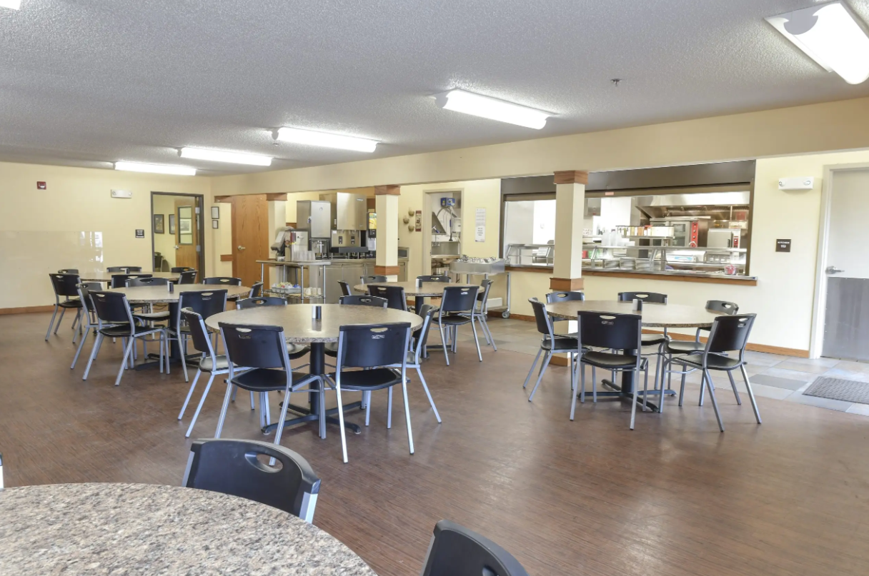 Community dining area with tables and cafeteria service window