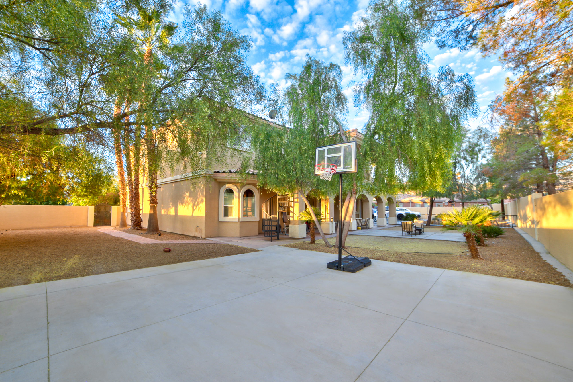 Backyard with a basketball court and a seating area.