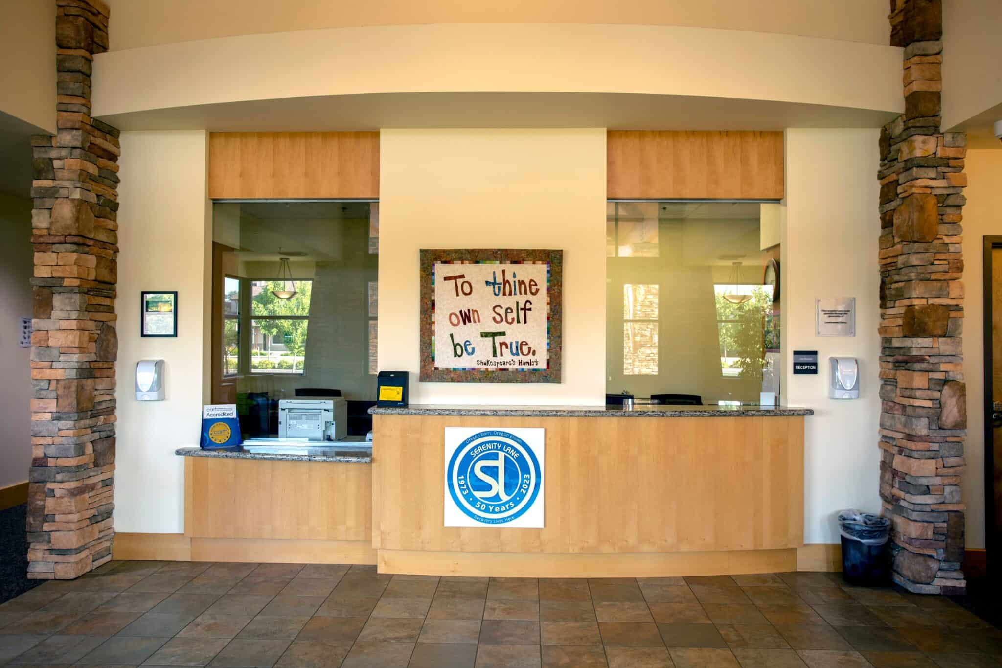 Front reception area with sign reading “To thine own self be true”