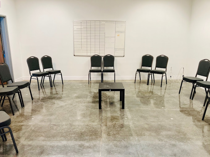 Spacious therapy room with chairs arranged in a circle, designed for group sessions in a comfortable setting.