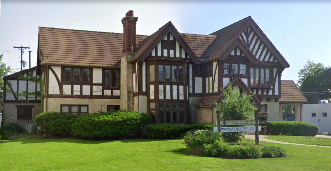 Large Tudor-style facility with landscaped lawn