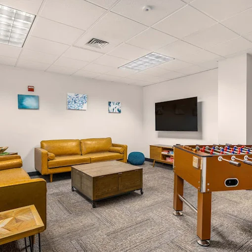 Game room with foosball table, couches, and wall-mounted TV
