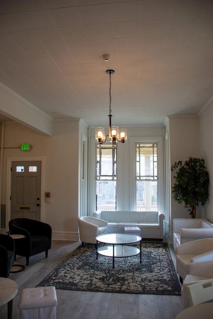 Rehab facility lounge with white sofas and tall windows