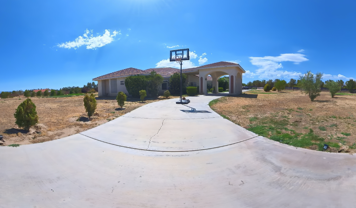 Outdoor basketball court on driveway under clear blue sky