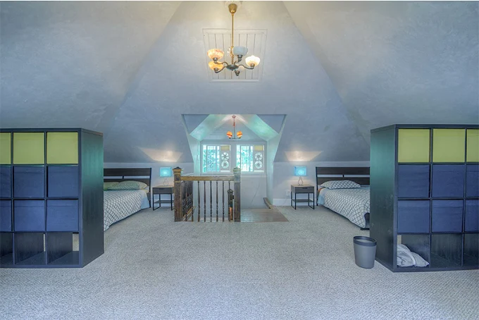 Spacious attic room with twin beds and storage units