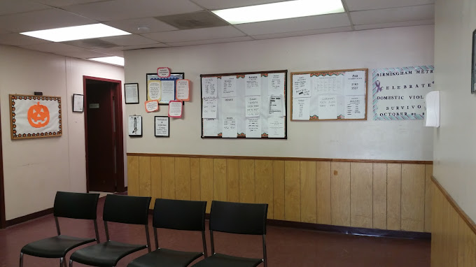 A waiting room with chairs and bulletin boards on the wall.