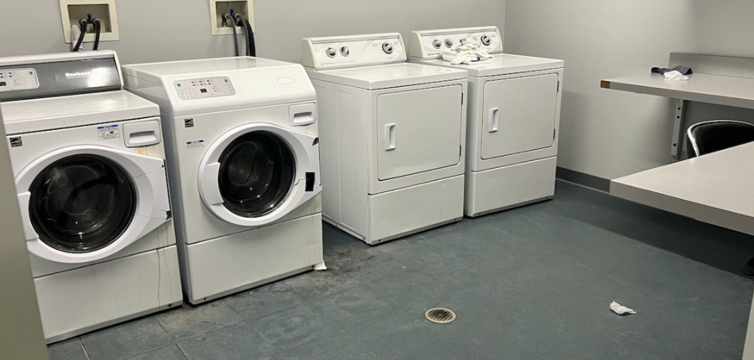 Laundry room with washers, dryers, and folding table