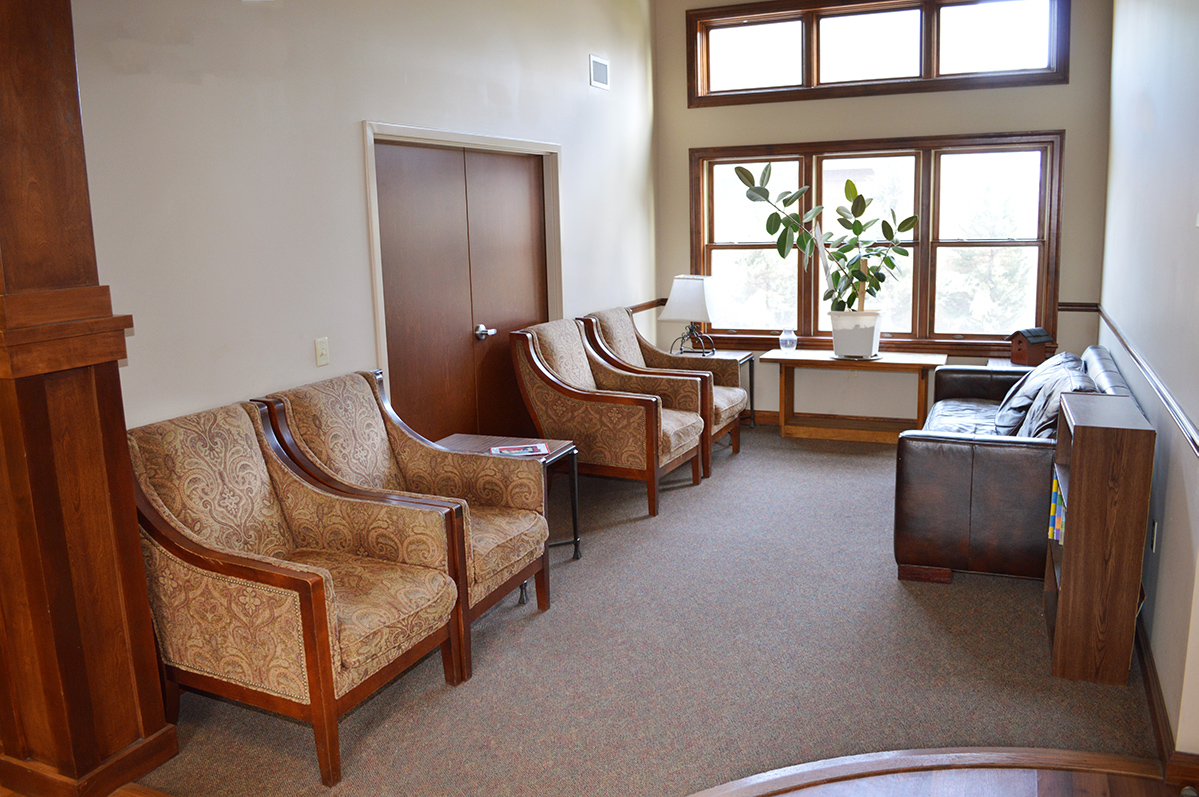 Lobby with upholstered chairs, sofa, and large windows