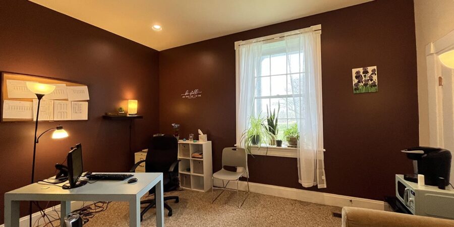 Desk and chairs in a brown-walled counseling office