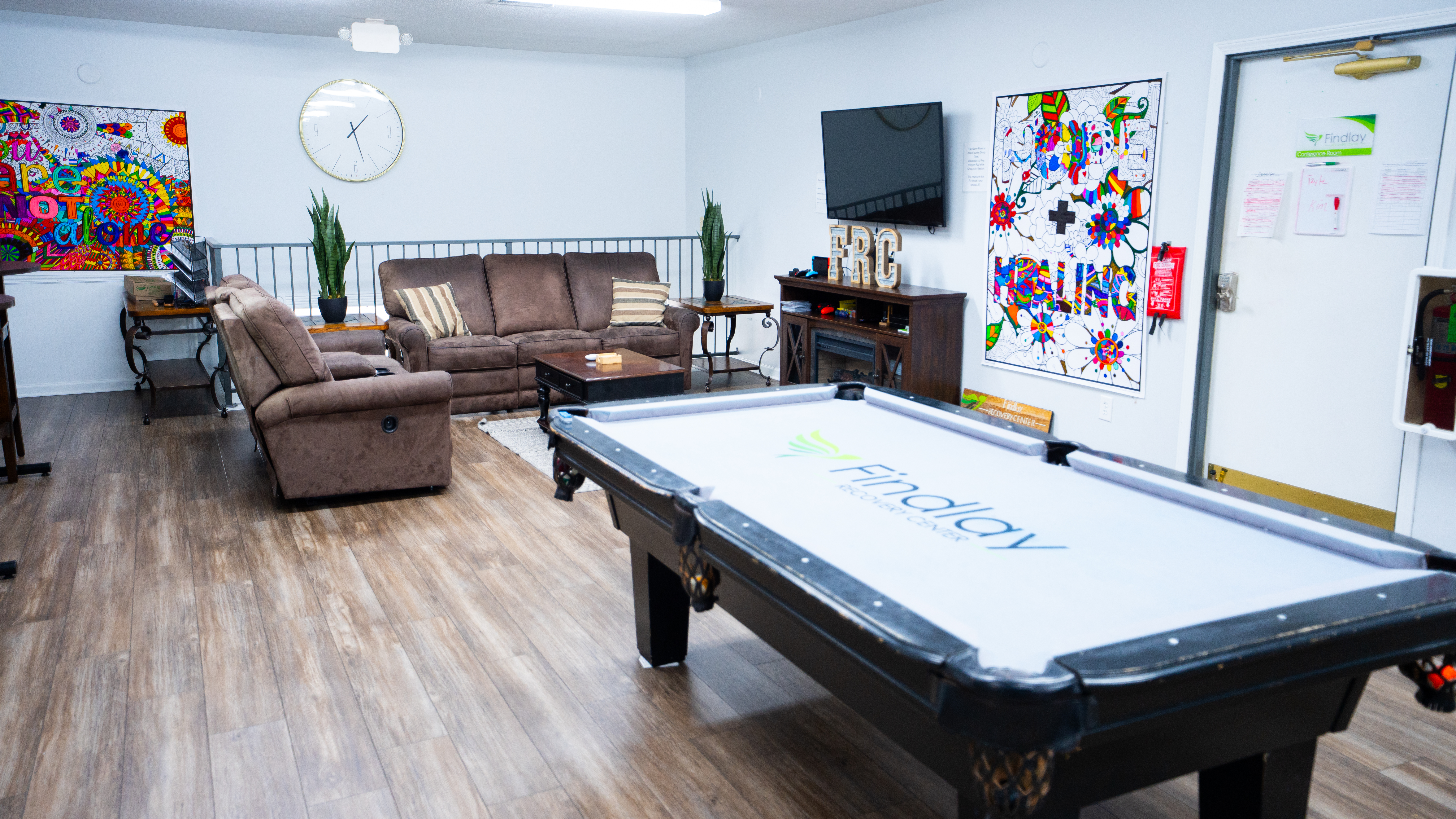 Cozy lounge with sofas, pool table, and colorful art