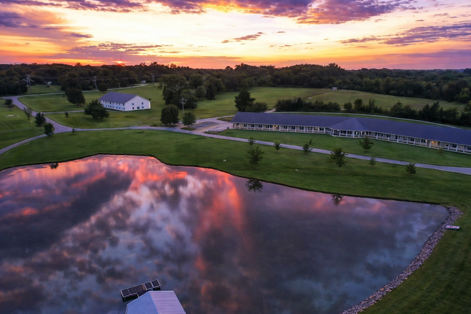 Aerial view of campus buildings beside a lake at sunset