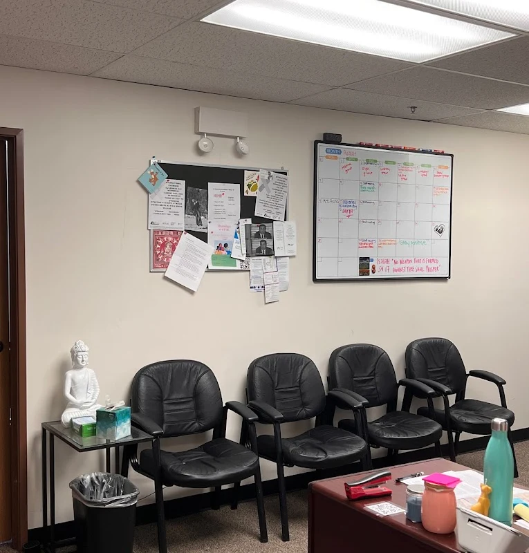 Black chairs lined up against a wall in a waiting room