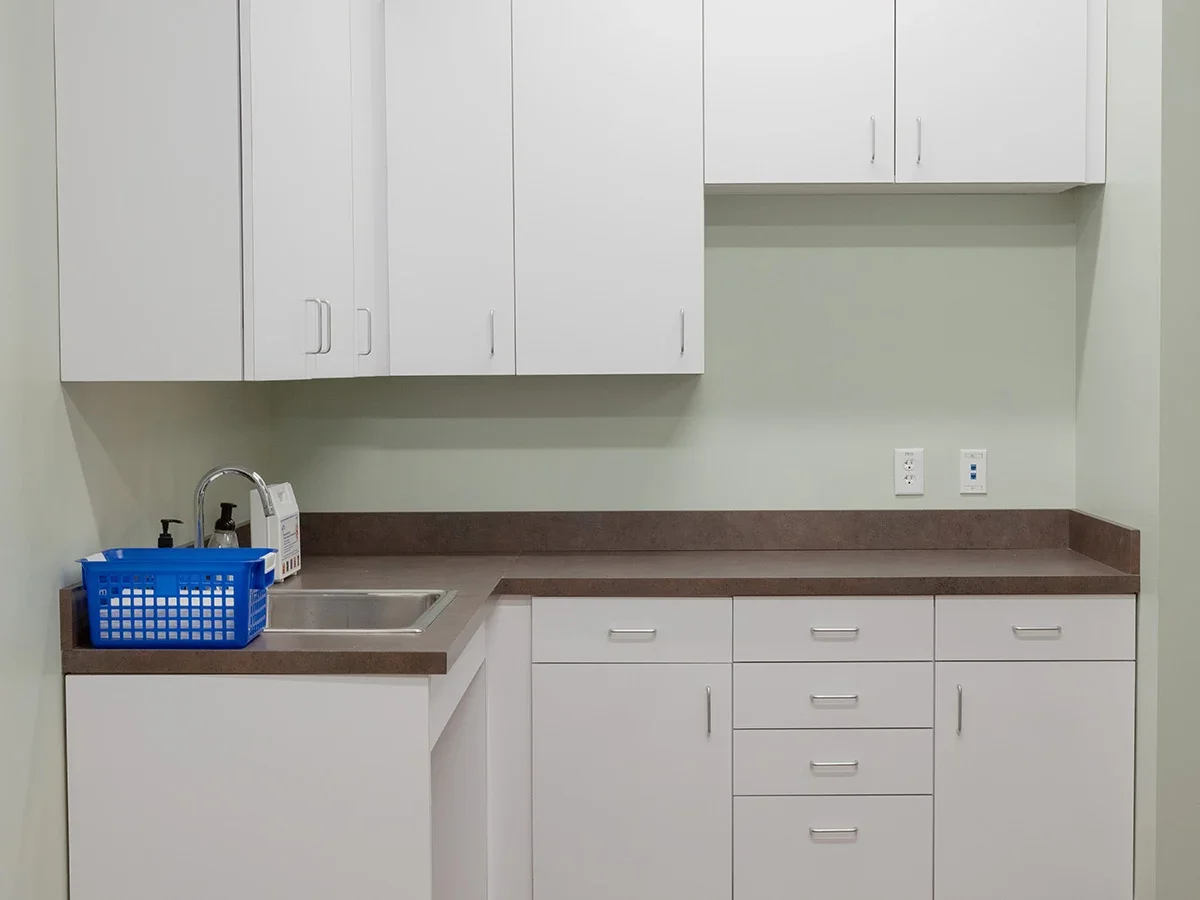 Clinic lab with sink, cabinets, and countertop workspace