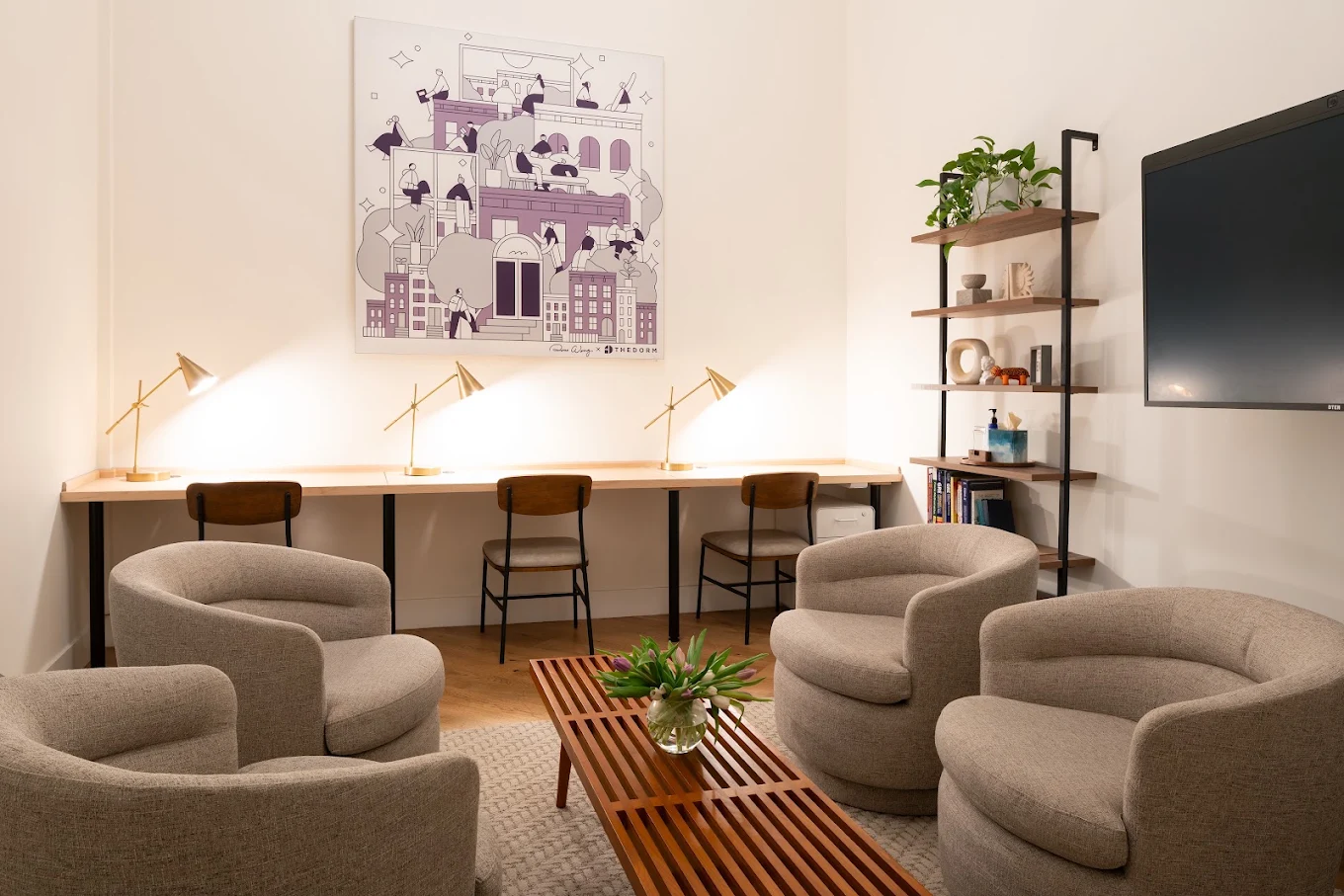 Study lounge with armchairs, desks, shelving, and television