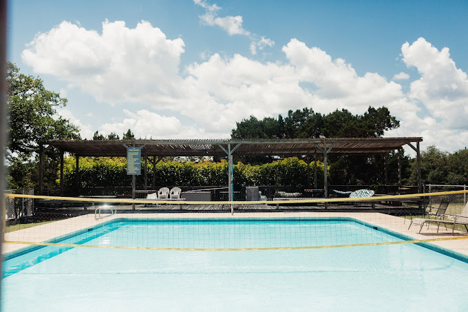 Pool with volleyball net and shaded lounge area