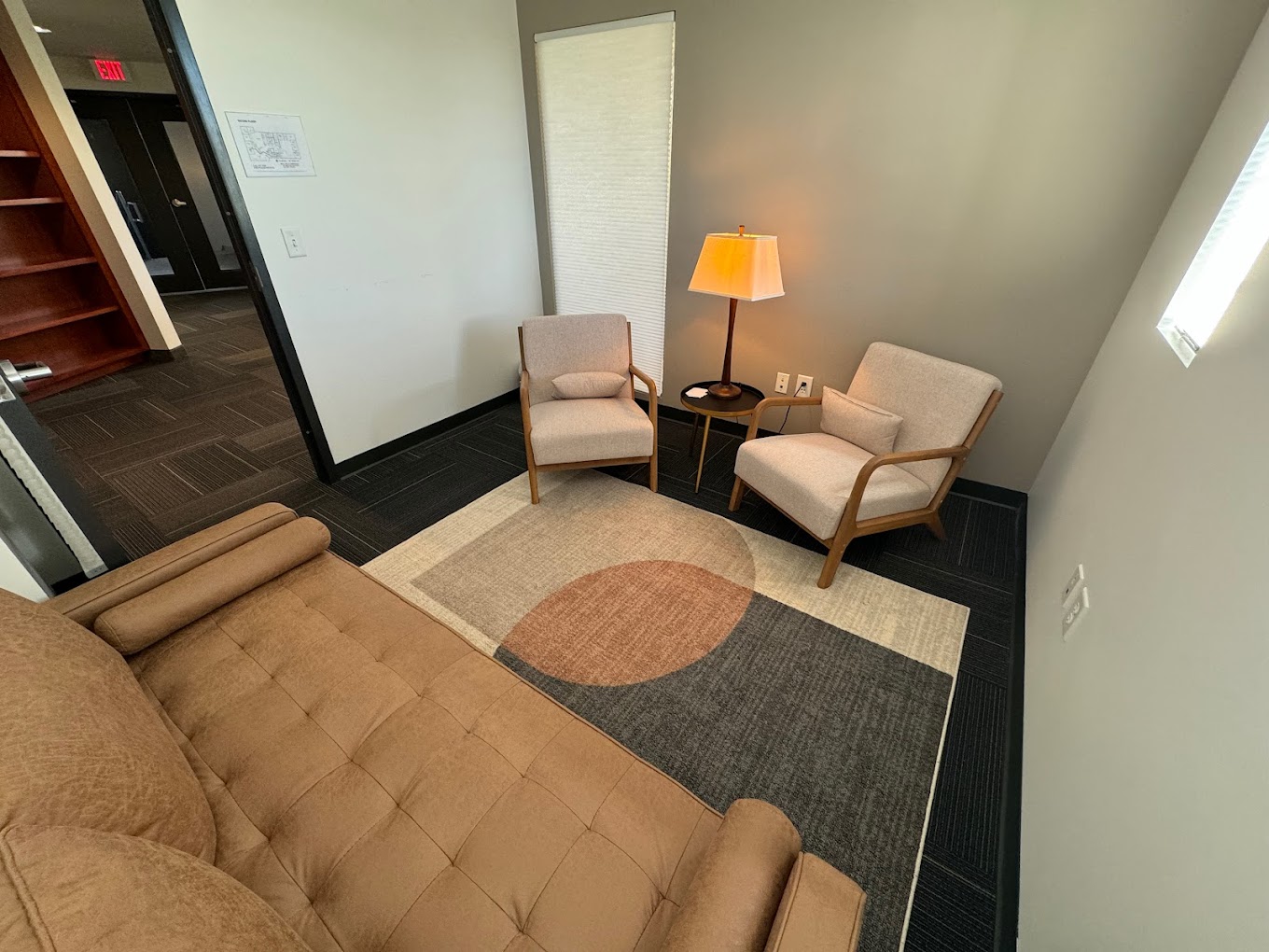 Small therapy room with beige chairs and a cozy atmosphere.