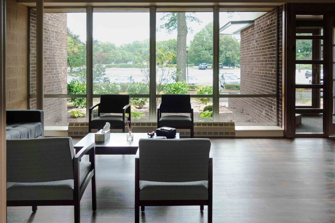 Waiting area with seats, large window, and decor.