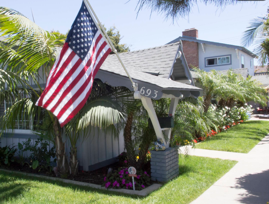 House exterior with U.S. flag and lush landscaping