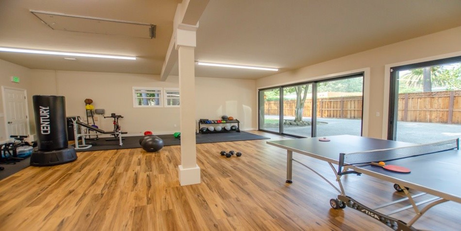 Recreation room with gym equipment and ping pong table
