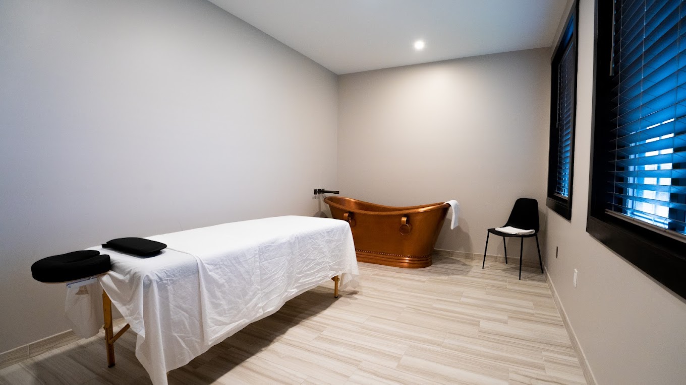 Private treatment room with massage table and copper soaking tub.