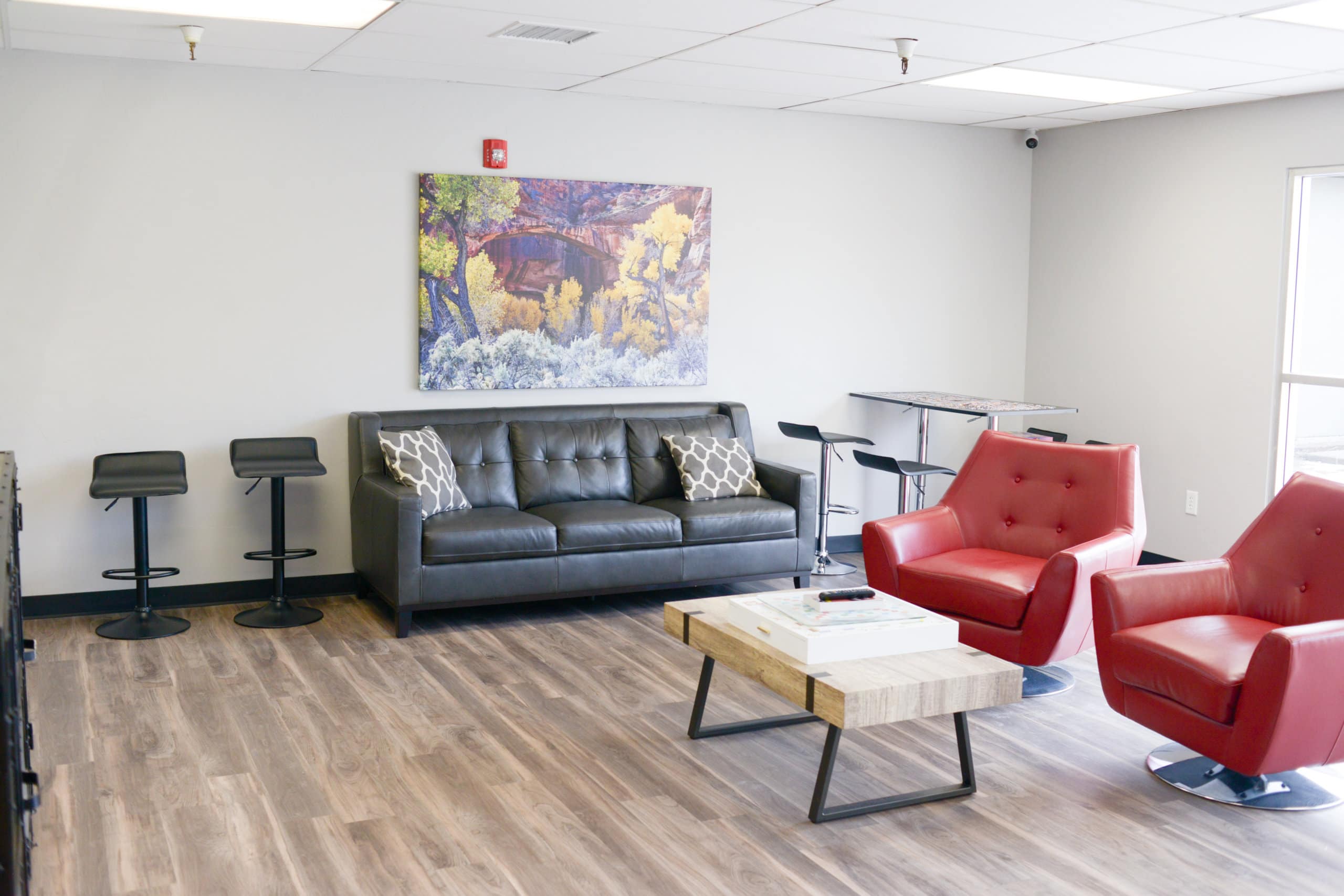 Red chairs and gray sofa with modern barstools nearby