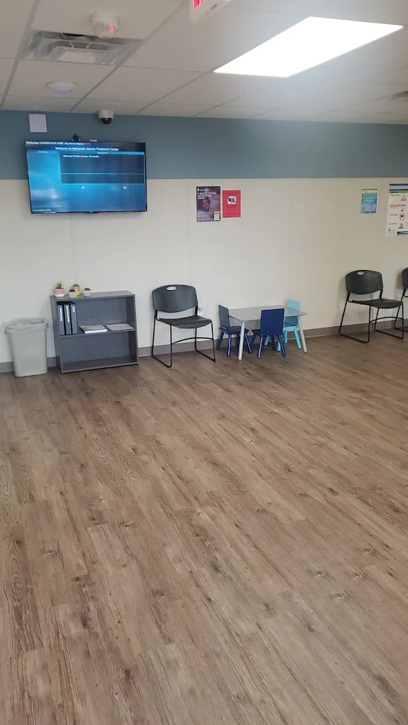 Waiting area with seating, TV, and children's activity table