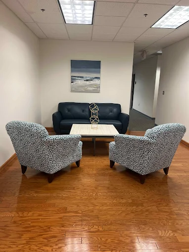 Small seating area with sofa, chairs, and modern decor