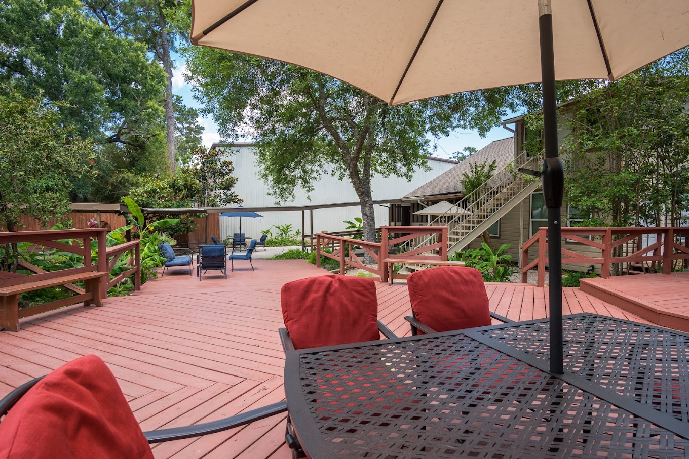 Outdoor deck with chairs and an umbrella.