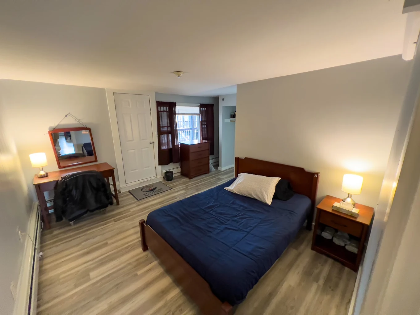 Bedroom with a single bed, nightstands, and wood flooring