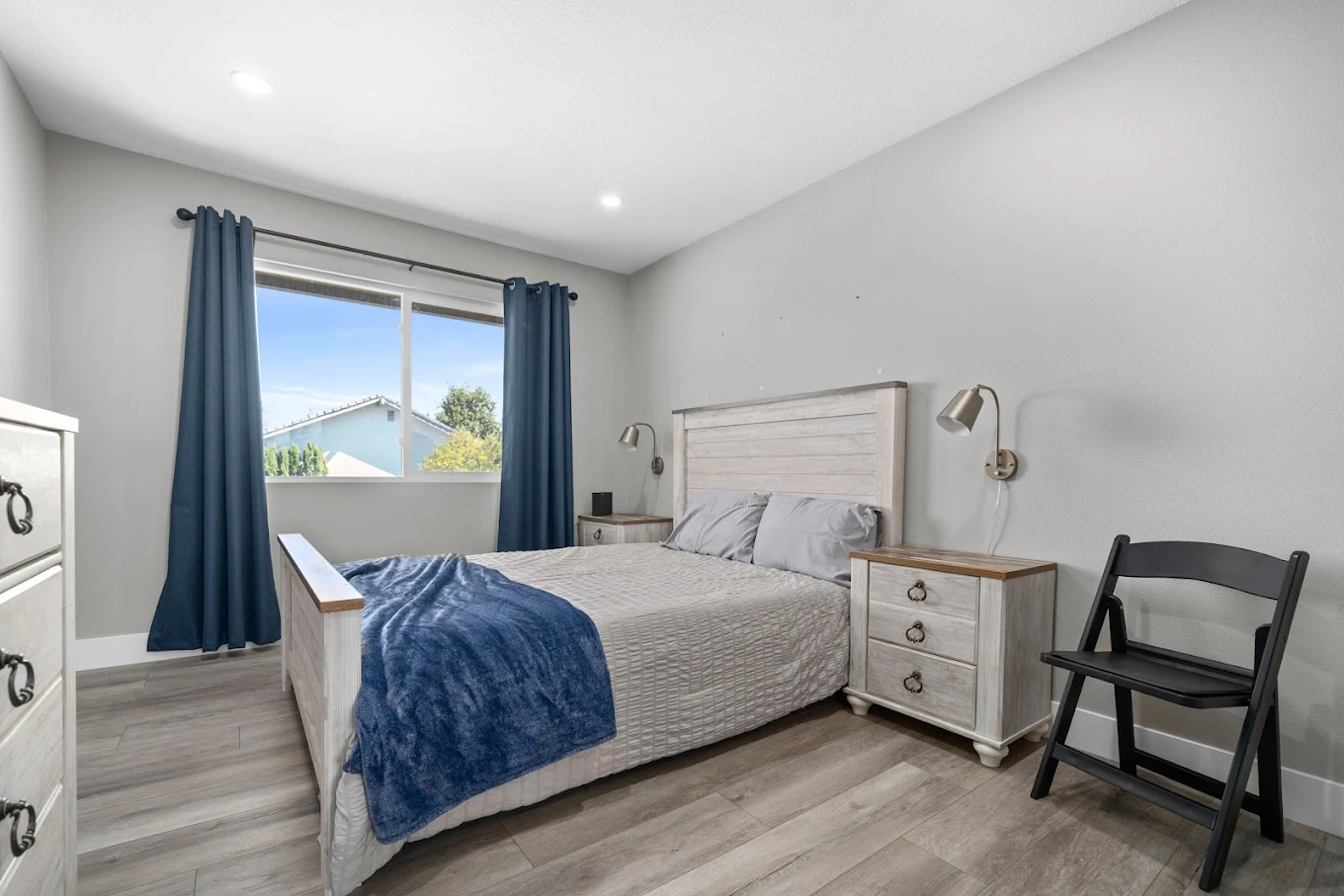 Cozy bedroom with wooden bed and blue blanket
