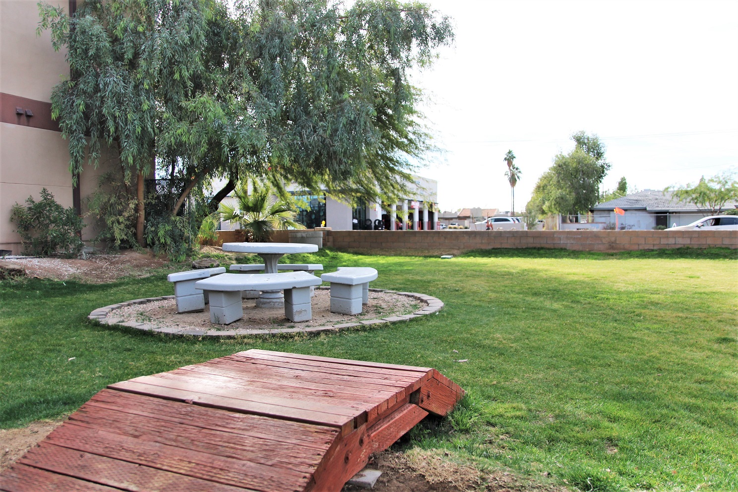 Lawn area with round concrete picnic table surrounded by trees