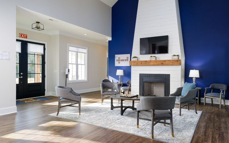 Modern lounge with fireplace, chairs, and blue accent wall