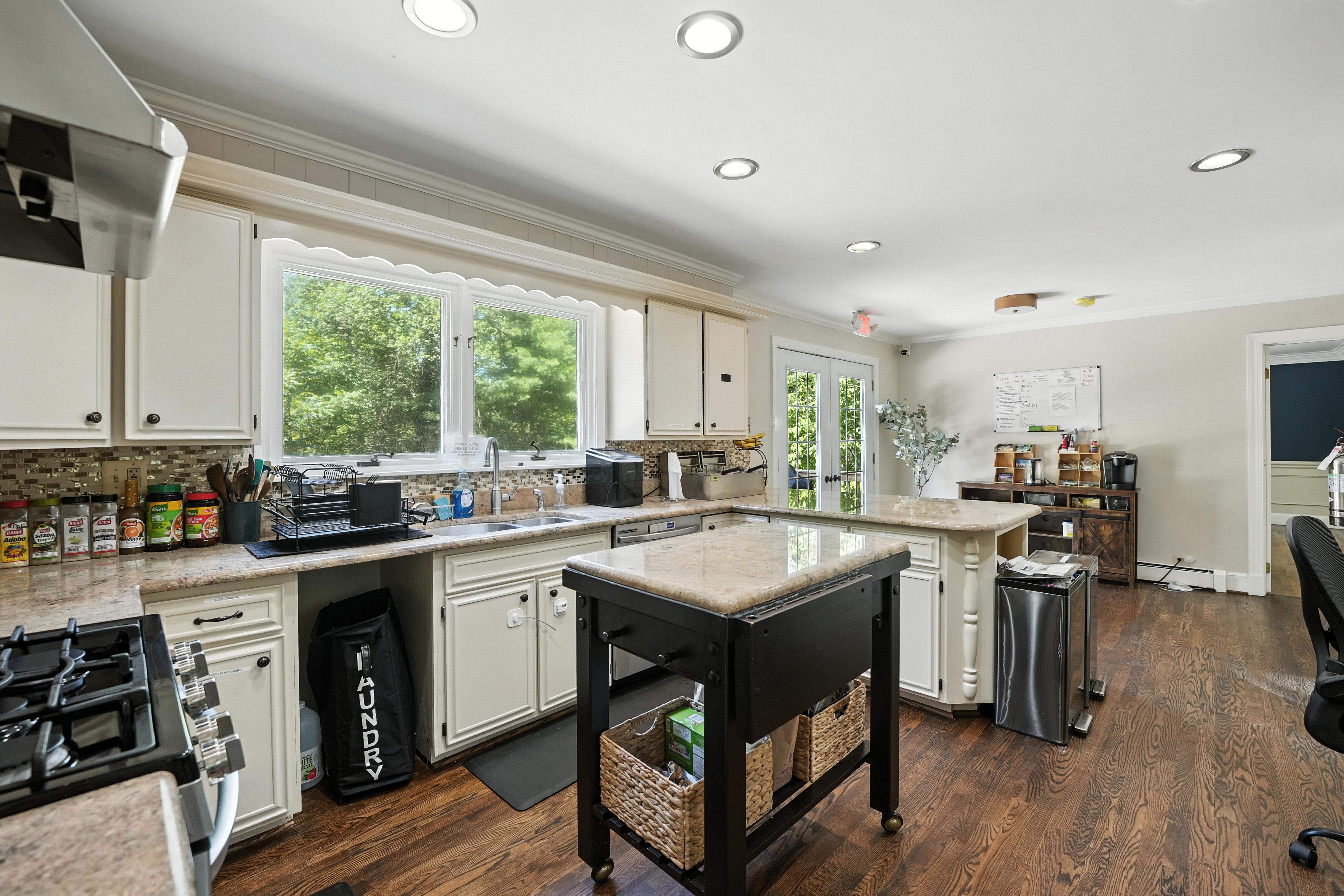 Spacious kitchen with island, cabinets, and hardwood floors